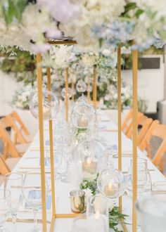 a long table with white and blue flowers on it is set up for an event