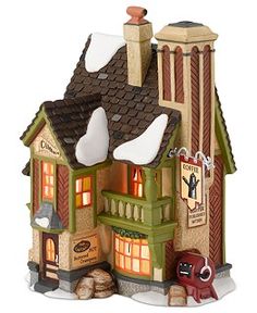 a toy house with lights and decorations on the roof, sitting in front of a white background