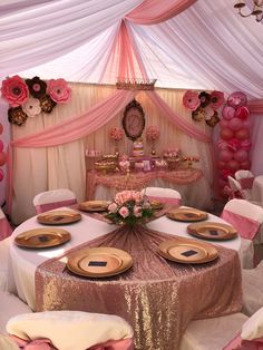 a table set up for a party with pink and gold decorations