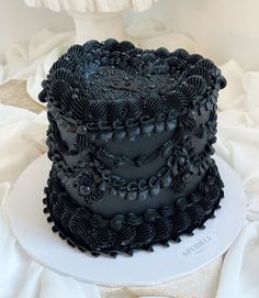 a three layer black cake sitting on top of a white plate