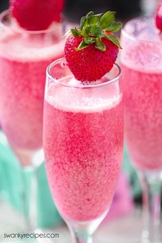 two glasses filled with pink liquid and topped with a strawberry