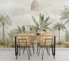 a dining table with four chairs in front of a tropical wallpapered background that has palm trees on it