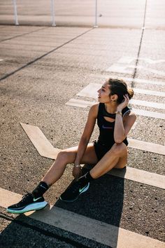 a woman sitting on the ground talking on her cell phone