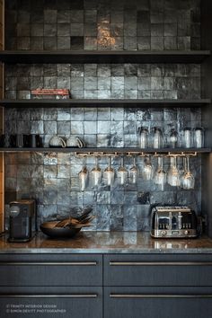 a kitchen with black cabinets and shelves filled with glass jars on top of it's counters