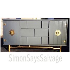 a gray cabinet with gold handles and knobs