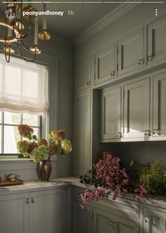 a kitchen filled with lots of counter top space next to a window covered in flowers