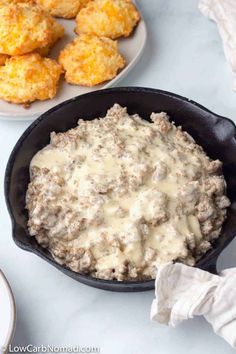 a skillet filled with meat and cheese next to some fried chicken nuggies