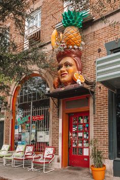 a large statue of a woman wearing a pineapple on top of her head in front of a store