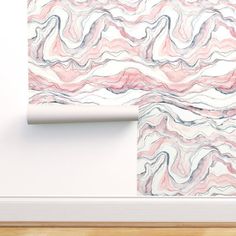 a white wall with pink and grey marbled paper on it next to a wooden floor