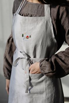 a woman is wearing an apron and has her hands in her pockets