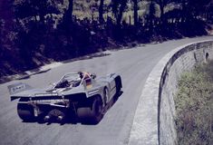 a car that is sitting on the side of a road with trees in the background