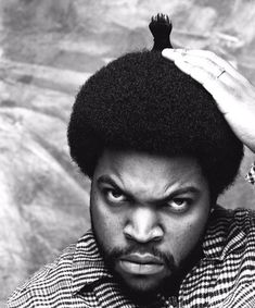 a black and white photo of a man with an afro on top of his head