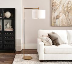 a living room with a white couch and a black bookcase in front of it