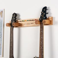 two guitars are hanging on the wall next to each other