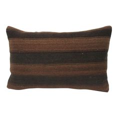 a brown and black striped pillow on a white background