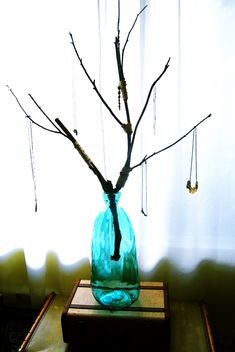 a vase filled with branches sitting on top of a table