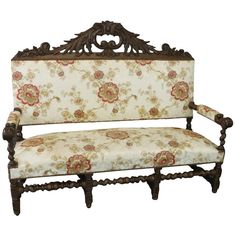 an ornate wooden bench with floral upholstered fabric on the seat and backrest