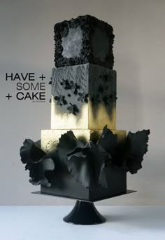 a three tiered cake with black and gold icing