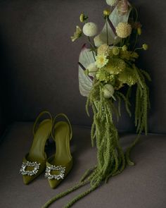 a bouquet and pair of green shoes sitting on a couch