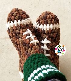 someone is wearing crocheted slippers that are brown and white with green trims