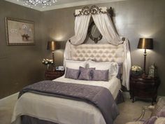 a bedroom with a bed, two lamps and a chandelier over it's headboard