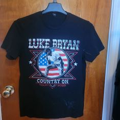 a t - shirt hanging on a door with the words luke brown country on it