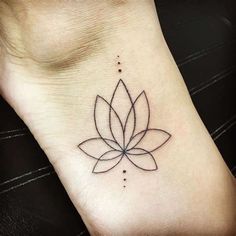 a lotus tattoo on the foot of a woman's left ankle, with dots in it