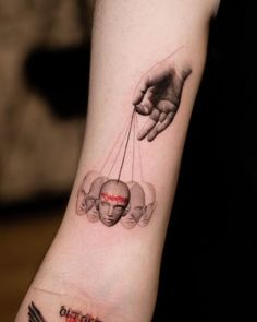 a person with a tattoo on their arm holding an object in one hand and the other