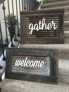 two wooden signs sitting on top of a carpeted stair case next to a banister