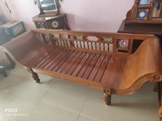 a wooden crib sitting in the corner of a room next to a dresser and mirror