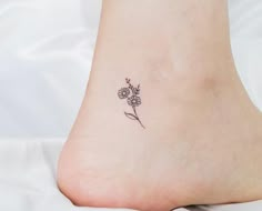 a small flower tattoo on the ankle