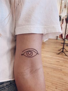 a woman's arm with an eye tattoo on it