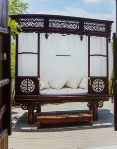 a canopy bed sitting on top of a wooden bench