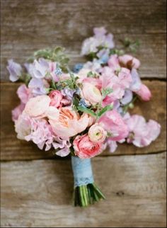 a bouquet of flowers sitting on top of a wooden table