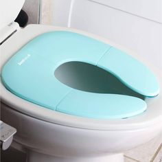 a toilet seat with the lid open and an electronic device attached to it's side