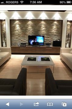 a living room filled with furniture and a flat screen tv sitting on top of a wooden table