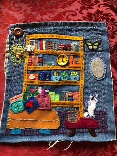 a piece of art made out of old jeans and fabric with cats sitting on it