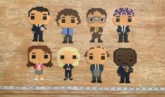 six pixellated people are standing in front of a measuring tape on a piece of wood