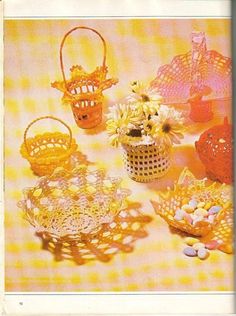 there are many crocheted baskets and flowers on the table with yellow gingham cloth