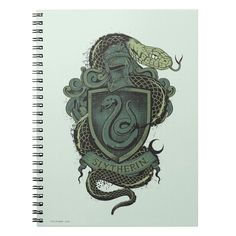 a spiral notebook with an image of a snake and shield on the front, surrounded by snakes