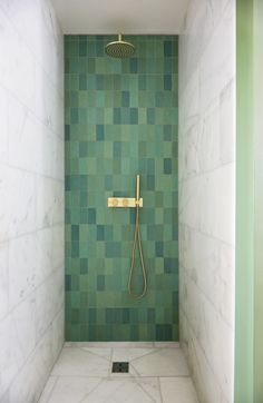 a green tiled shower stall in a bathroom