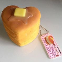 a heart shaped pastry with a piece of butter on it's side next to a tag