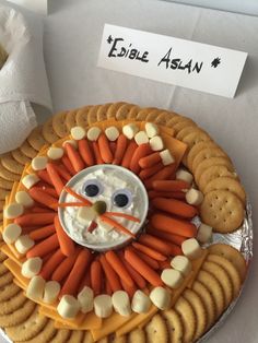 a plate topped with crackers and carrots covered in cheese