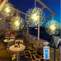 fireworks are lit up in the night sky above tables and chairs with remotes on them