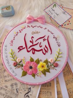 the embroidery is decorated with flowers and musical notes in arabic writing on a white background