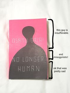 a pink book with black writing on the front and back cover that reads, no longer human