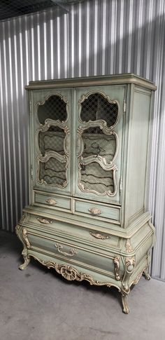 an old green china cabinet with glass doors