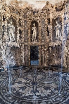 an intricately designed room with fountains and statues on the wall, in front of a circular mosaic floor