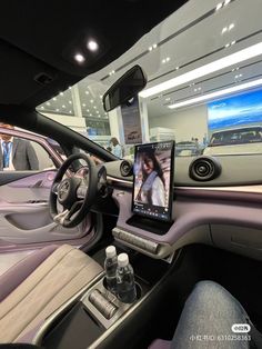 the interior of a car with an electronic device in it's center console and people walking by