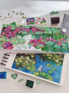 an artist's notebook with water lilies and other art supplies on the desk